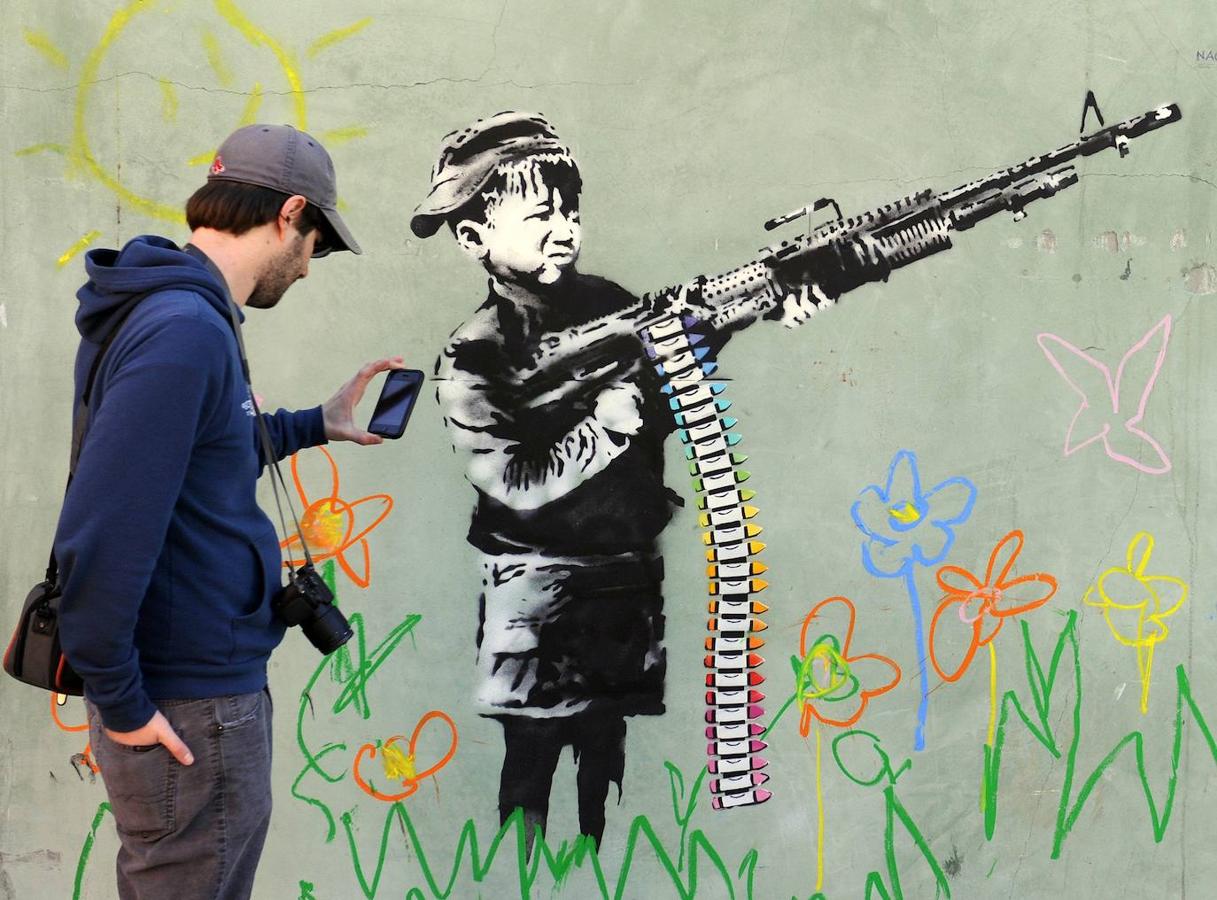 Las obras de arte urbano de Banksy son fotografiadas por gran cantidad de gente a diario. El artista combina la escritura con grafitis y plantillas