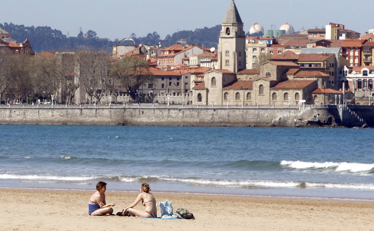 Dos mujeres disfrutan de la playa gijonesa este martes.