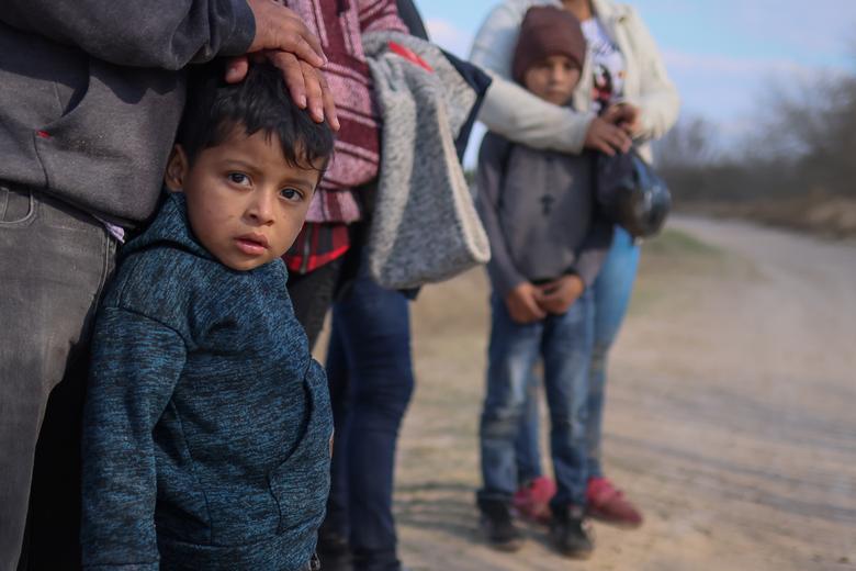 Eduardo Josué, de 4 años, de Honduras, espera el transporte en un camino de tierra después de cruzar el Río Grande.