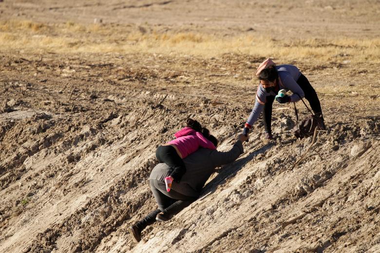 Los migrantes salen del río Bravo después de cruzarlo para convertirse en agentes de la Patrulla Fronteriza de Estados Unidos y solicitar asilo.