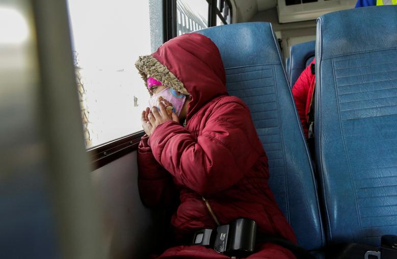 Una niña migrante de Centroamérica, bajo el programa de Protocolos de Protección al Migrante (MPP), mira por la ventana de un autobús mientras es llevada a un refugio después de cruzar de México a Estados Unidos para continuar con su solicitud de asilo en Estados Unidos.