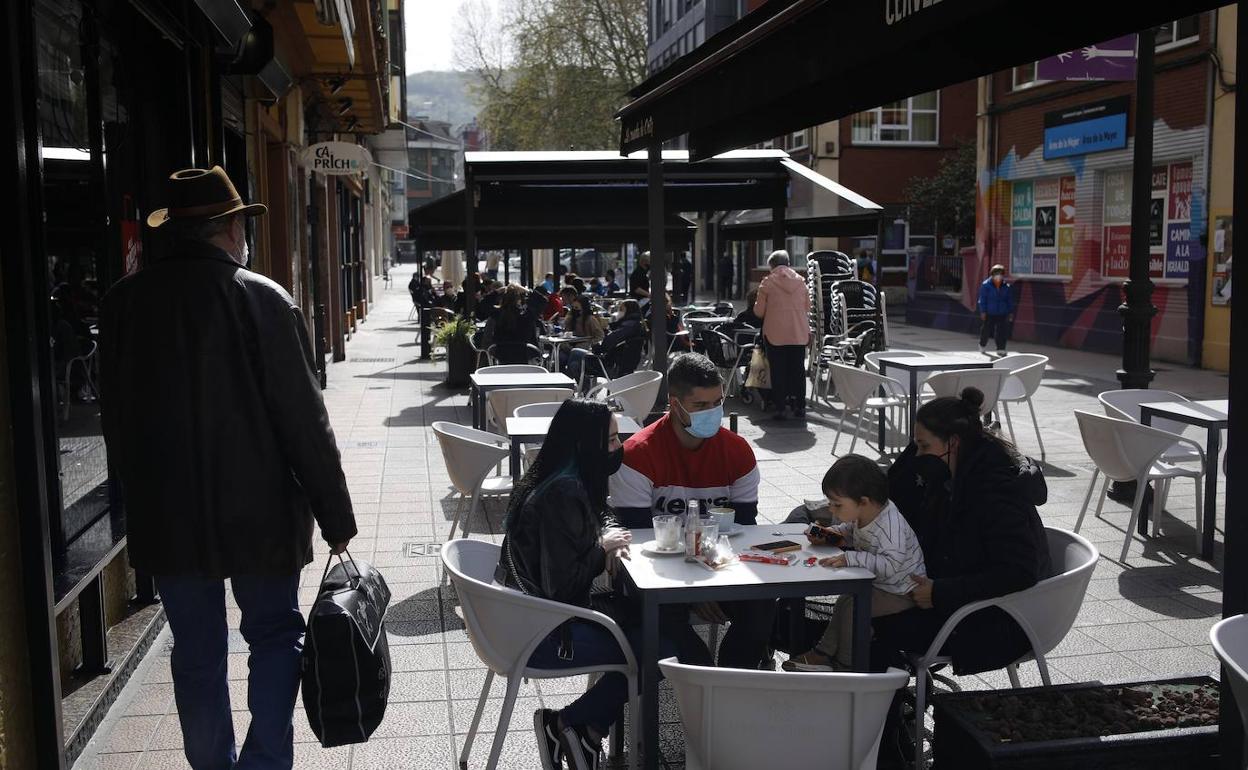 Vecinos de La Felguera disfrutaban del sol antes del cierre perimetral del concejo. 