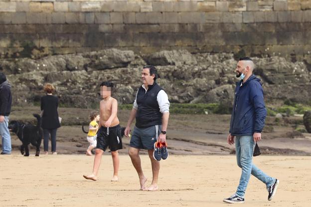 Paseantes en la playa de San Lorenzo, en Gijón, ayer. En el vídeo, la opinión de los gijoneses sobre la obligatoriedad del uso de la mascarilla.