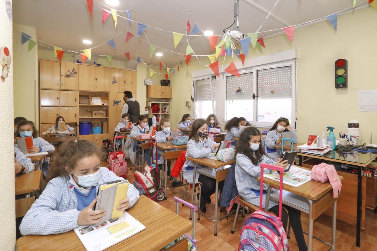 La clase de quinto de Primaria, revisando las presentaciones en la tablet. 