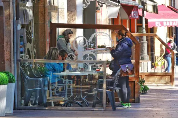Unos clientes de un bar de Cangas de Onís toman una consumición en la terraza del establecimiento. 