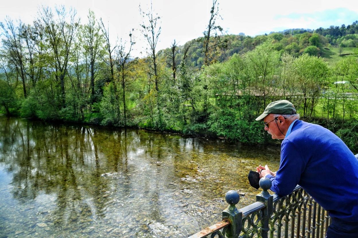 Quico 'el Molineru' observa el Sella desde el puente de Villanueva de Cangas de Onís. 