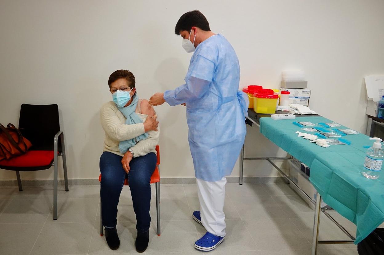 Un enfermero inyecta la vacuna de Pfizer a una vecina de Ribadesella en el centro de salud de esta localidad. 