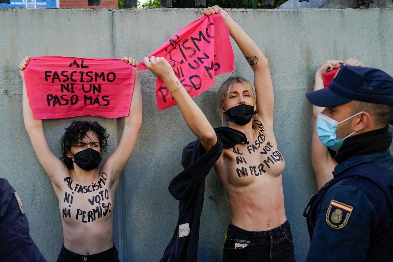 Cuatro activistas de Femen con el torso desnudo han protestado ante el colegio electoral del barrio de Chamartín donde debe votar la candidata de Vox, Rocío Monasterio.