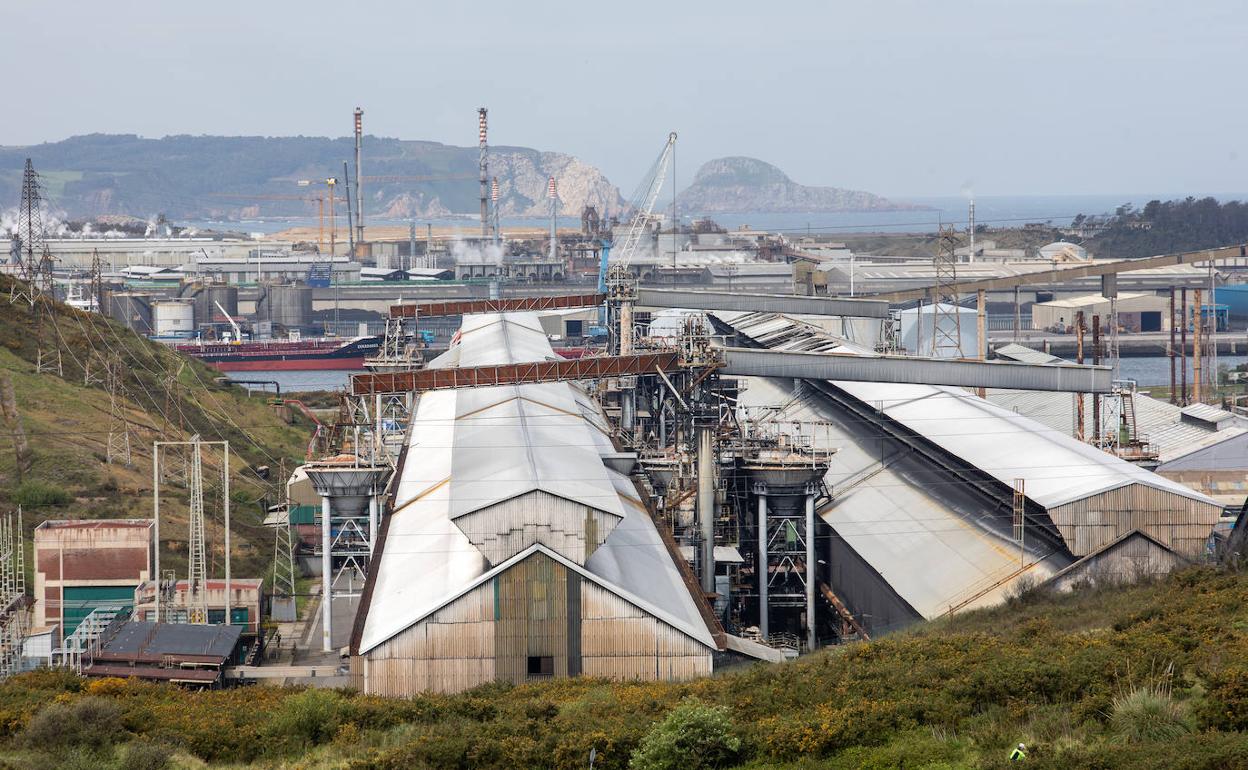 Vista general de la planta de Alu Ibérica en Avilés, con el puerto y la ría al fondo. 