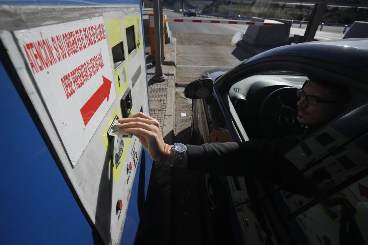 Un conductor procede a pagar el peaje de la autopista del Huerna. 