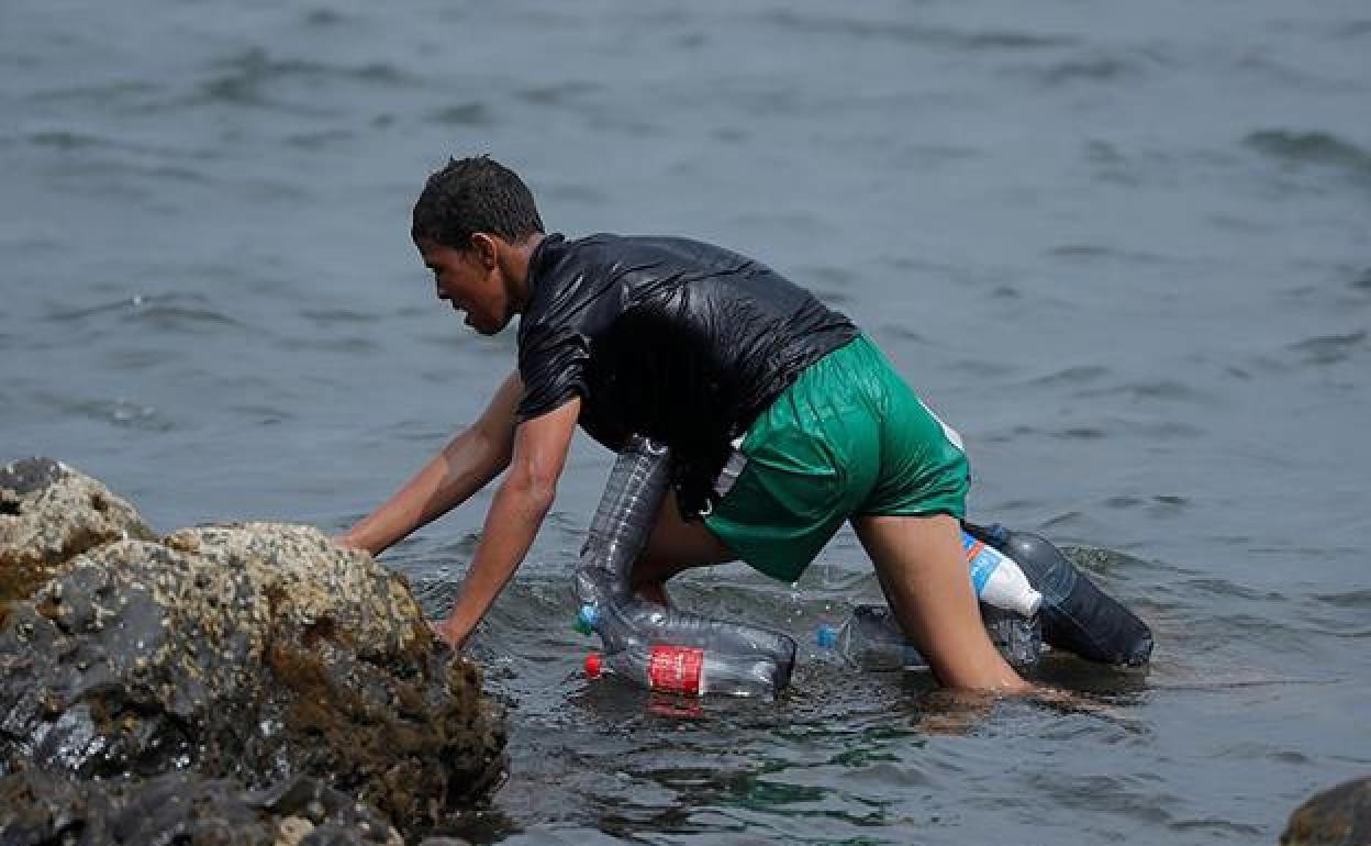 Aschraf intentó entrar en Ceuta por el mar, ayudado por un flotador creado con botellas de plástico.