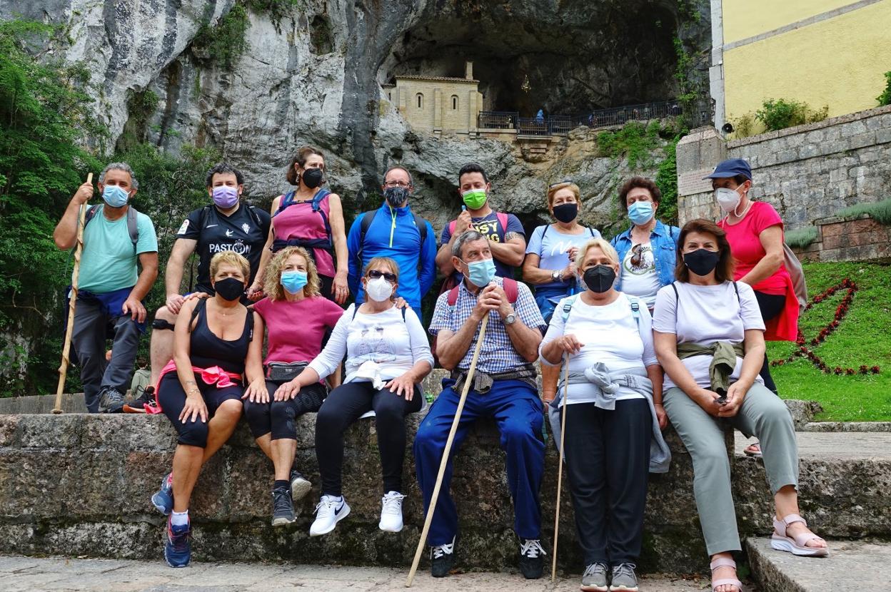 Un grupo de los peregrinos llaniscos posa ante la Santa Cueva mientras el resto asisten a misa. 