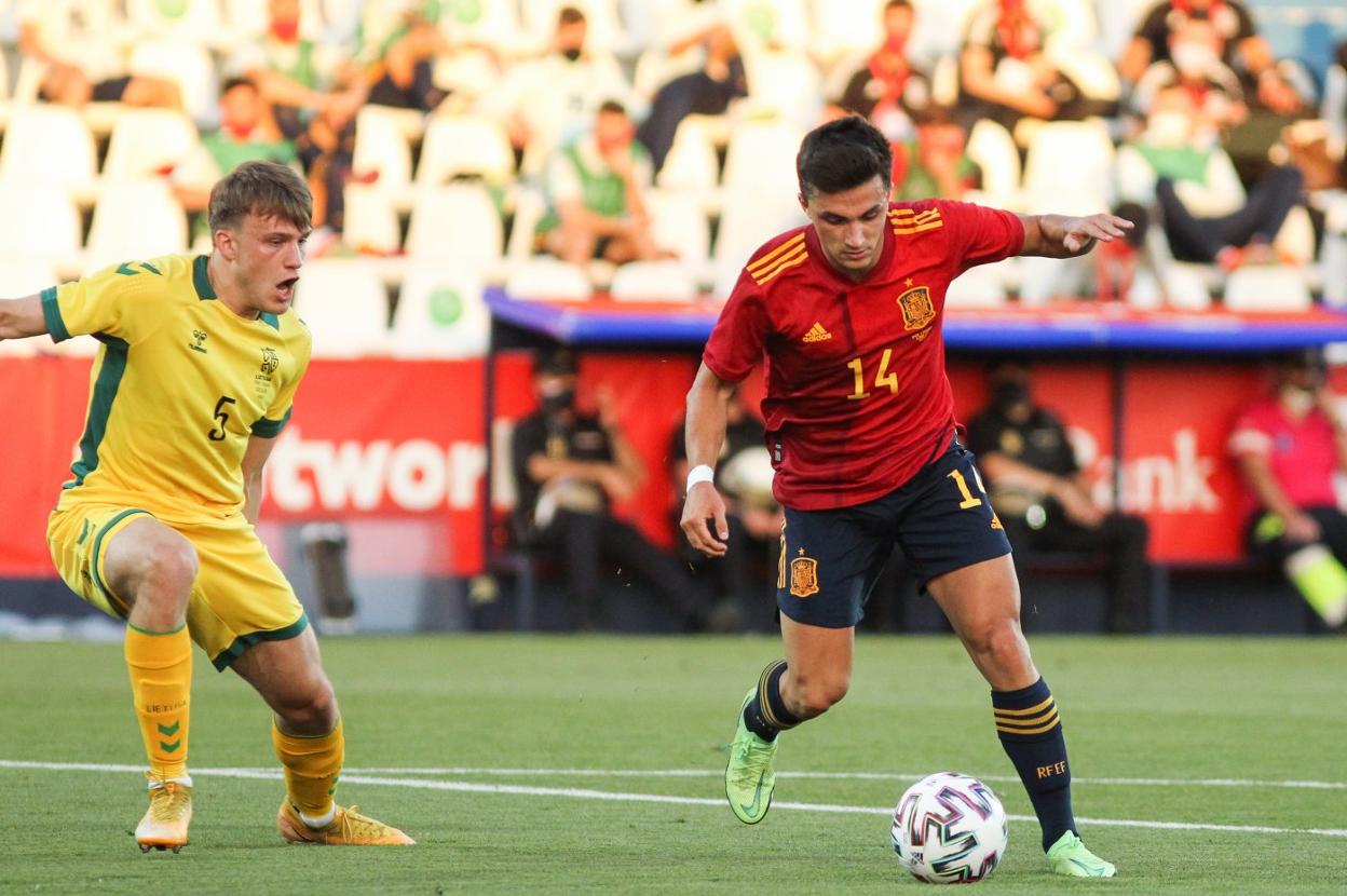 Manu intenta un regate ante un futbolista de Lituania antes de tener que abandonar el campo lesionado. 