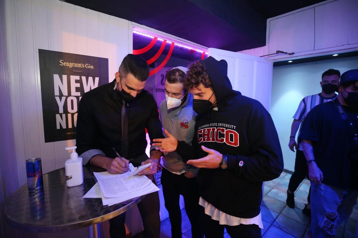 El empleado de un bar de Oviedo anota los nombres de dos clientes para acceder al local. 