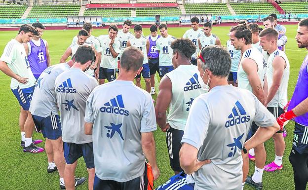 La plantilla al completo escucha las indicaciones de Luis Enrique durante el entrenamiento de ayer. 