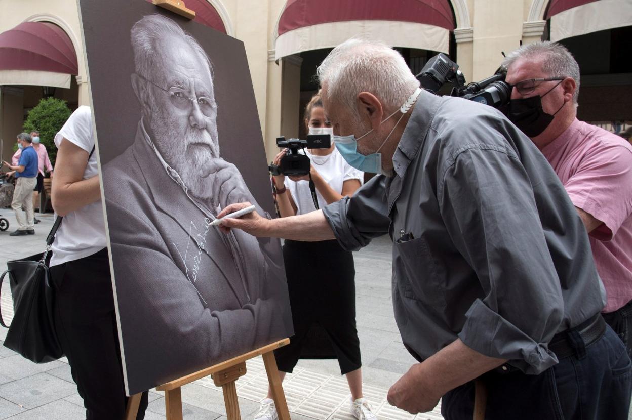 Gonzalo Suárez, rubricando un retrato suyo en el Festival Internacional de Cine de Huesca. 