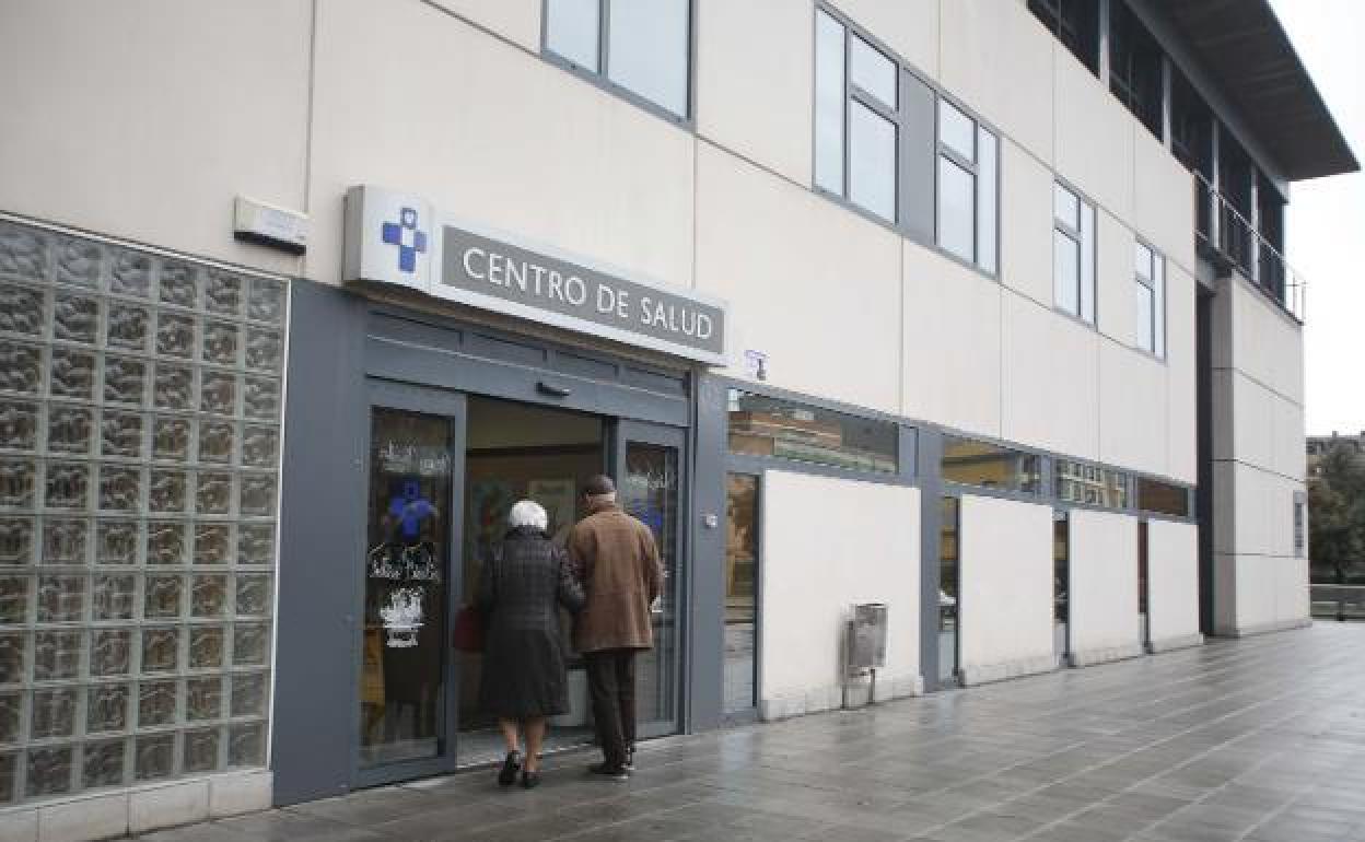 Dos personas mayores entran en un centro de salud.