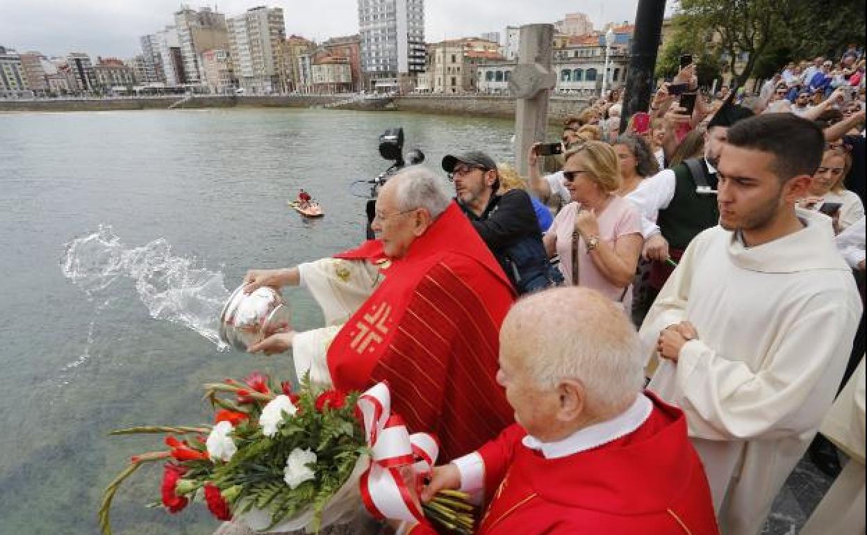 El párroco de San Pedro, Javier Gómez, bendiciendo las aguas de la bahía de San Lorenzo en 2019