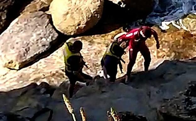 Momento del rescate de uno de los pasajeros de la moto.