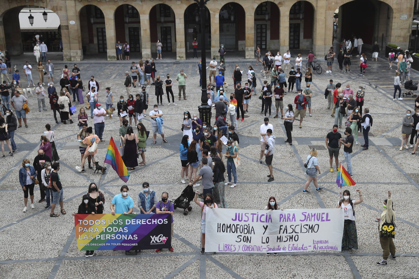  Los colores de la bandera arcoíris han llenado la Plaza Mayor de Gijón y la Escandalera de Oviedo. Decenas de personas se han concentrado este lunes en varios puntos de Asturias para justicia para Samuel, el joven que falleció a causa de una brutal paliza en A Coruña. Los primeros indicios apuntan a que se trata de una agresión homófoba y una amiga del fallecido que presenció la paliza ha explicado que los agresores le dijeron: «Para de grabarnos si no quieres que te mate, maricón»