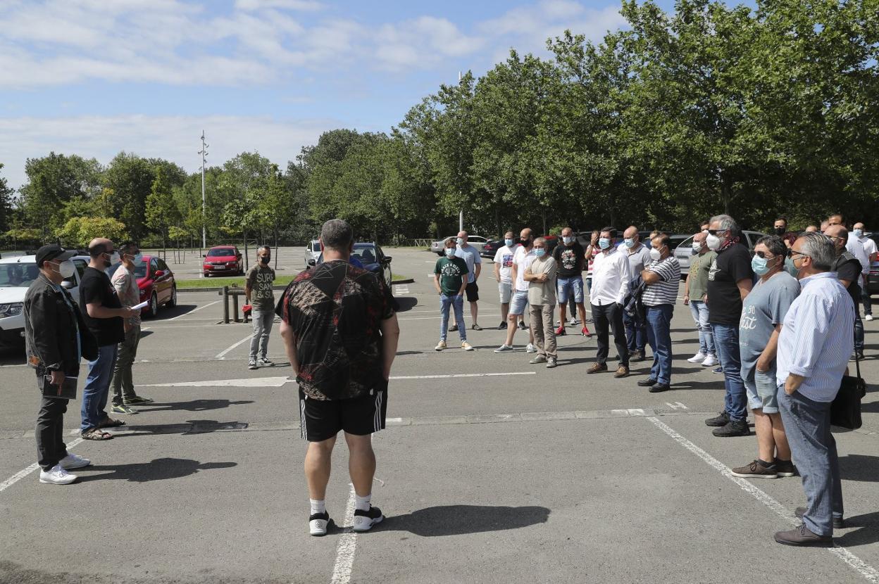 Trabajadores de la antigua Vauste en el parking del Palacio de los Deportes, en Gijón, donde el comité de empresa comunicó que la factoría entraba en liquidación. 