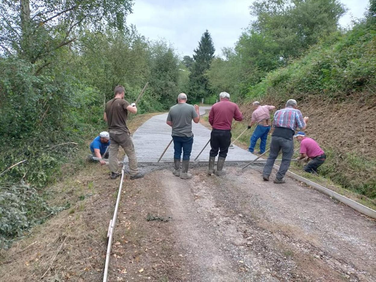 Los vecinos de Bimenes ayudan a reparar una carretera. 