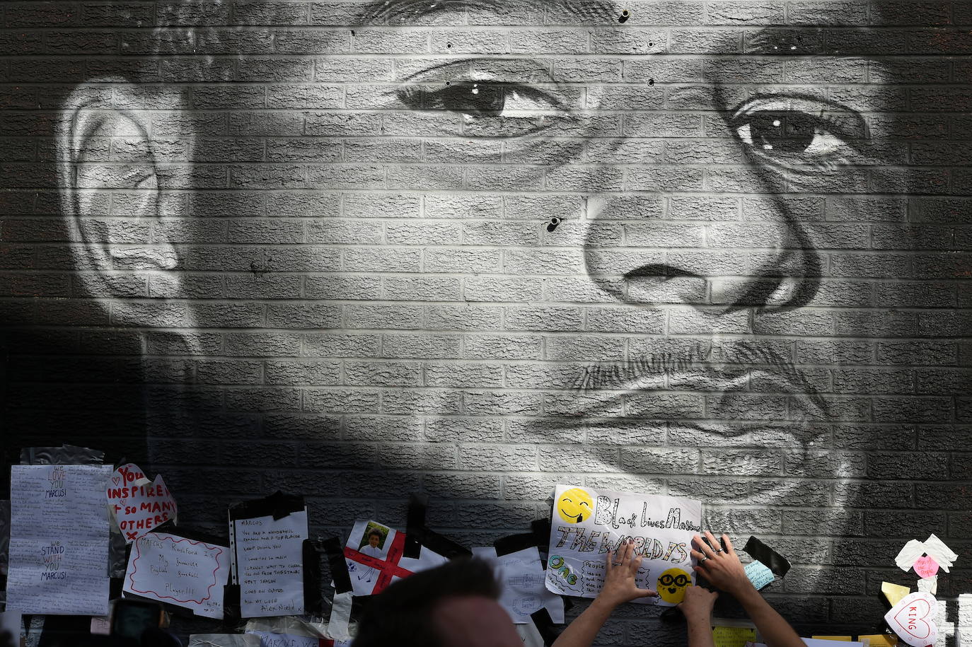 Un seguidor pega un cartelen un mural dedicado a Marcus Rashford que fue atacado tras la derrota de Inglaterra en la final de la Eurocopa. 