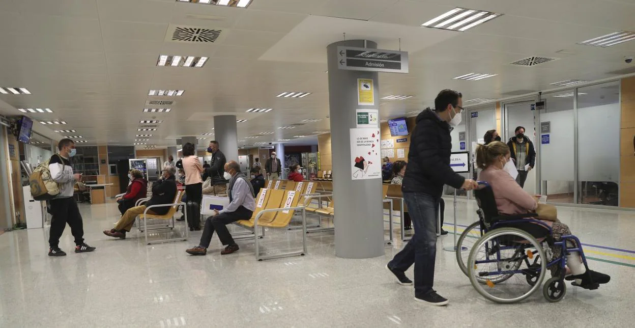 Varios pacientes, ayer, en la zona de atención al usuario ubicada en el hall principal de entrada del Hospital de Cabueñes. 