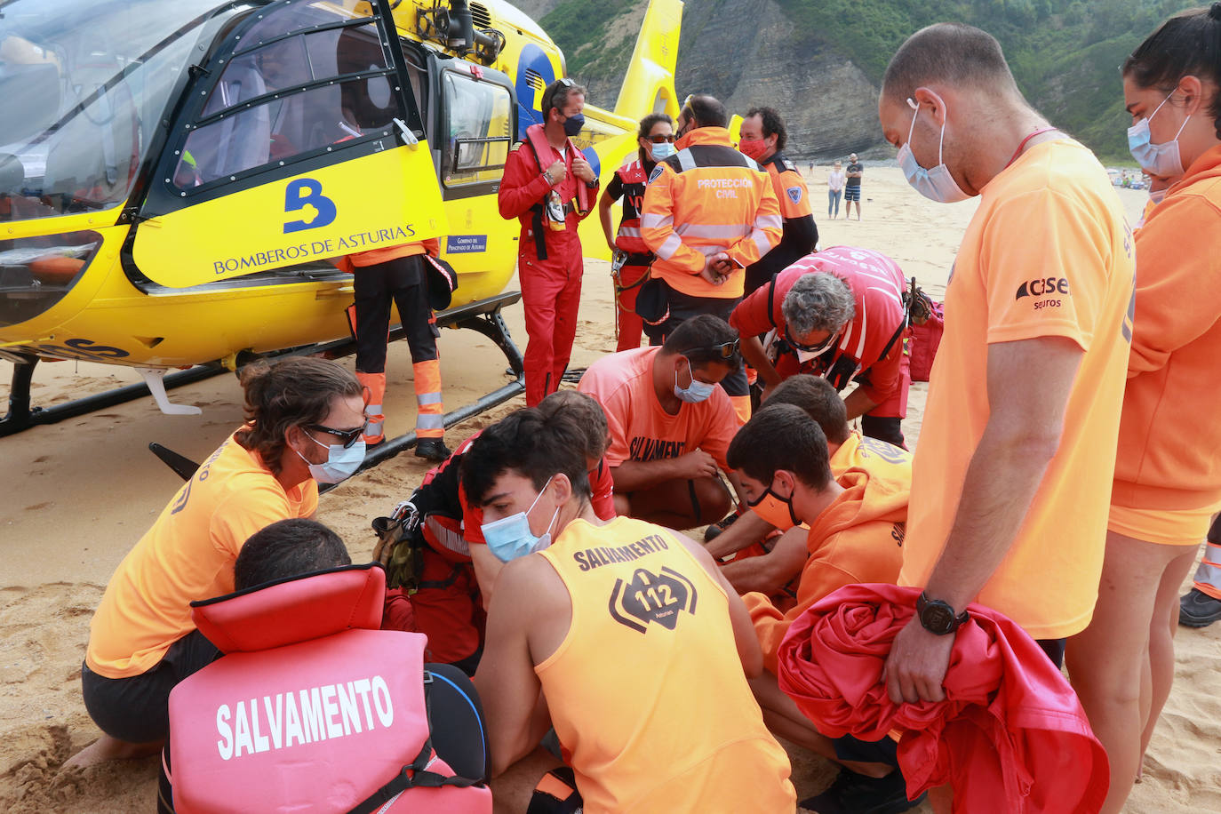 El helicóptero del Servicio de Emergencias del Principado realizó esta mañana un simulacro en la playa de Rodiles. La actuación, que contaba con la participación de más de veinte profesionales, despertó la curiosidad entre los bañistas. El objetivo de este simulacro es enseñar a los socorristas cómo actuar en caso de emergencia durante este verano. El equipo rescatador explicó cuál es la mejor zona para el aterrizaje y cómo deben prepararse.