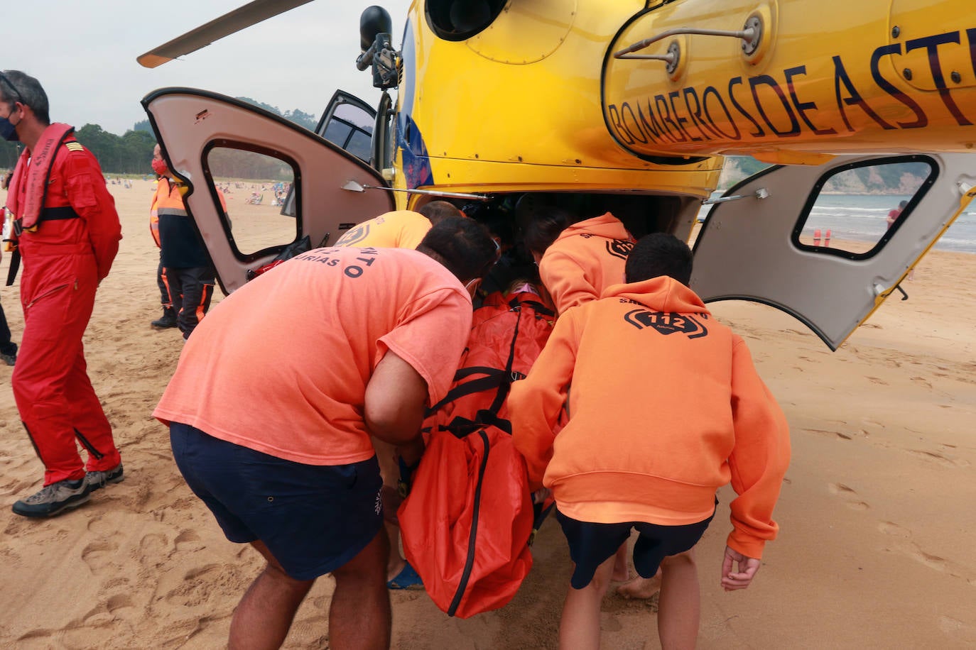 El helicóptero del Servicio de Emergencias del Principado realizó esta mañana un simulacro en la playa de Rodiles. La actuación, que contaba con la participación de más de veinte profesionales, despertó la curiosidad entre los bañistas. El objetivo de este simulacro es enseñar a los socorristas cómo actuar en caso de emergencia durante este verano. El equipo rescatador explicó cuál es la mejor zona para el aterrizaje y cómo deben prepararse.