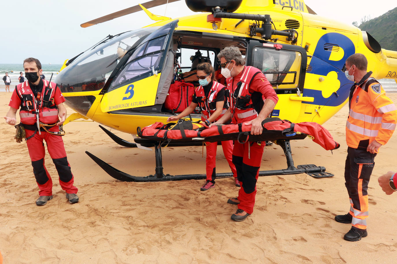 El helicóptero del Servicio de Emergencias del Principado realizó esta mañana un simulacro en la playa de Rodiles. La actuación, que contaba con la participación de más de veinte profesionales, despertó la curiosidad entre los bañistas. El objetivo de este simulacro es enseñar a los socorristas cómo actuar en caso de emergencia durante este verano. El equipo rescatador explicó cuál es la mejor zona para el aterrizaje y cómo deben prepararse.