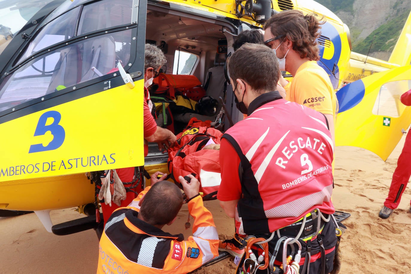 El helicóptero del Servicio de Emergencias del Principado realizó esta mañana un simulacro en la playa de Rodiles. La actuación, que contaba con la participación de más de veinte profesionales, despertó la curiosidad entre los bañistas. El objetivo de este simulacro es enseñar a los socorristas cómo actuar en caso de emergencia durante este verano. El equipo rescatador explicó cuál es la mejor zona para el aterrizaje y cómo deben prepararse.