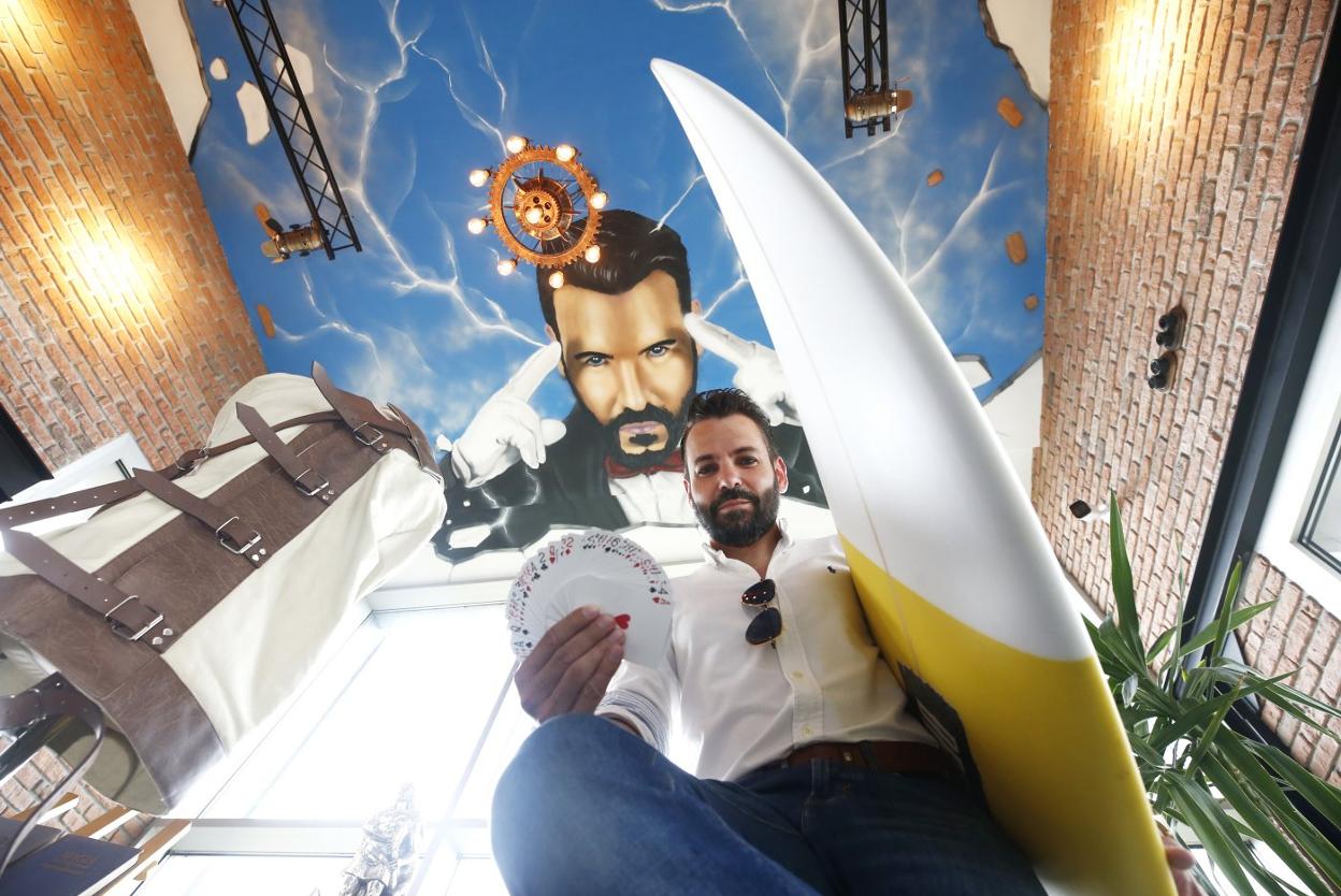 José Armas, en su oficina y sala de ensayo, armado con tabla de surf y baraja de póquer. 