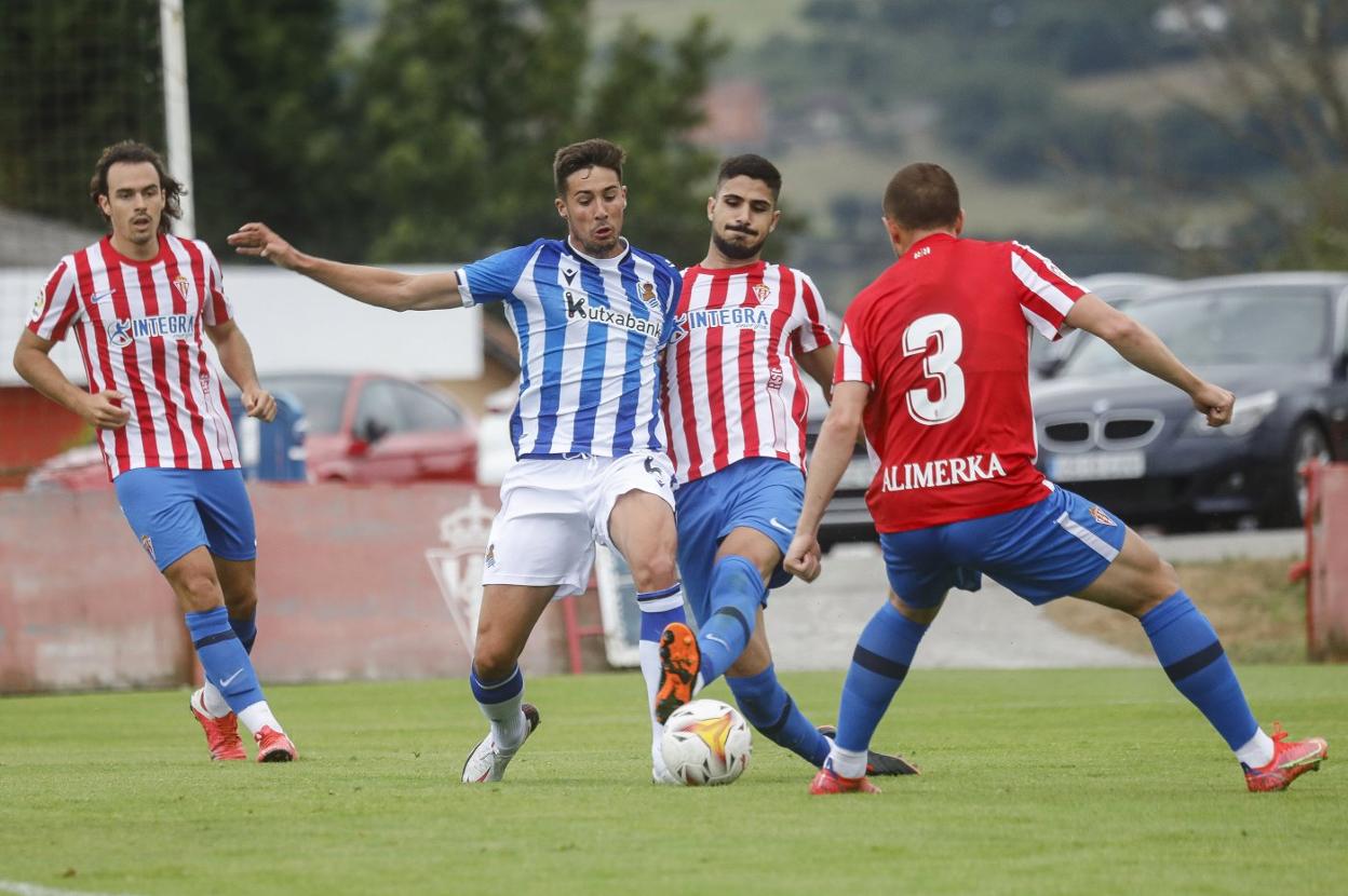 Berrocal, uno de los refuerzos del Sporting, pugna por un balón con el donostiarra Martón, con Kravets, de espaldas.