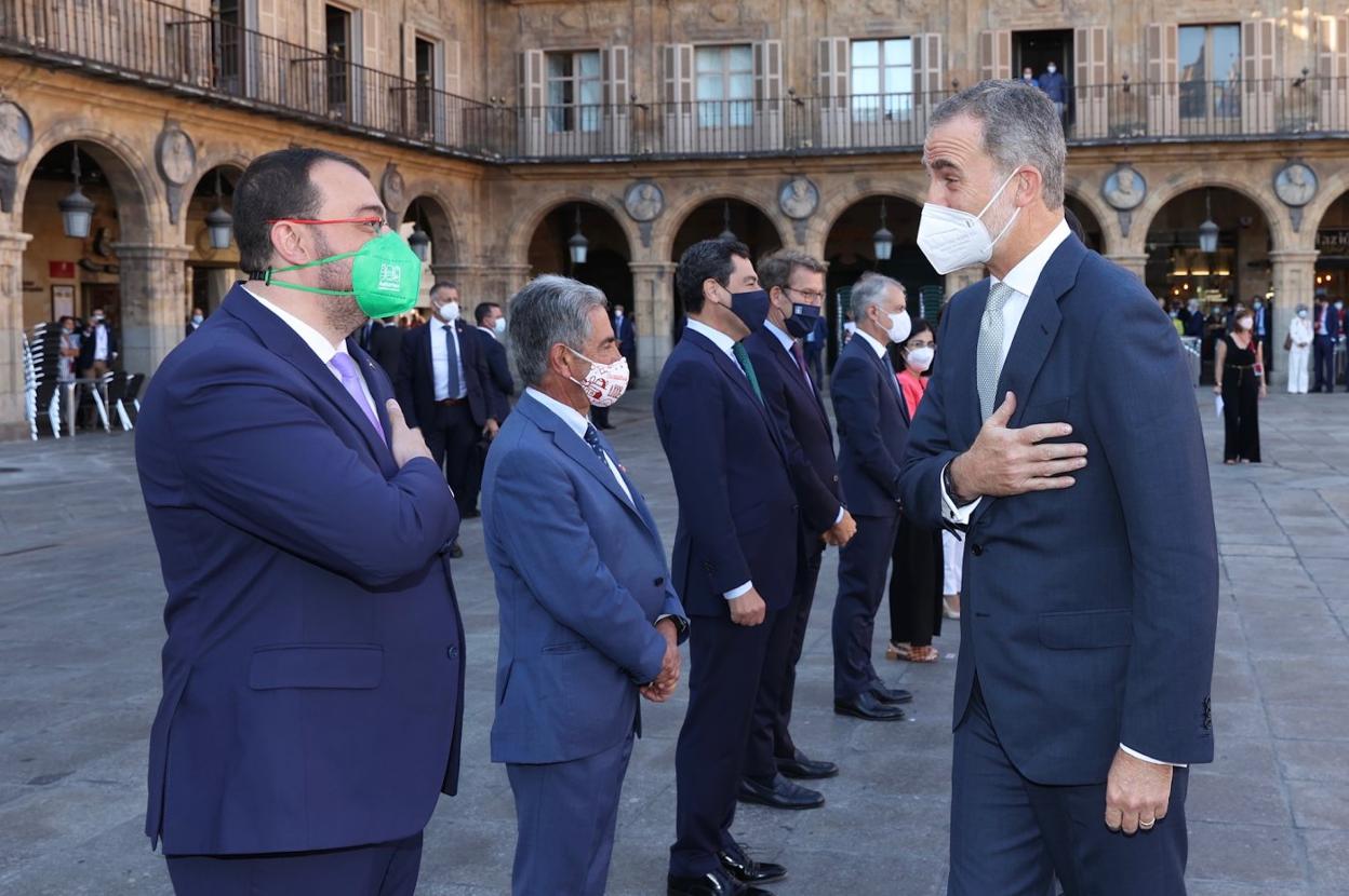 Adrián Barbón y el Rey, Felipe VI, se saludan con la mano en el pecho en la plaza Mayor de Salamanca, en los prolegómenos del encuentro. 