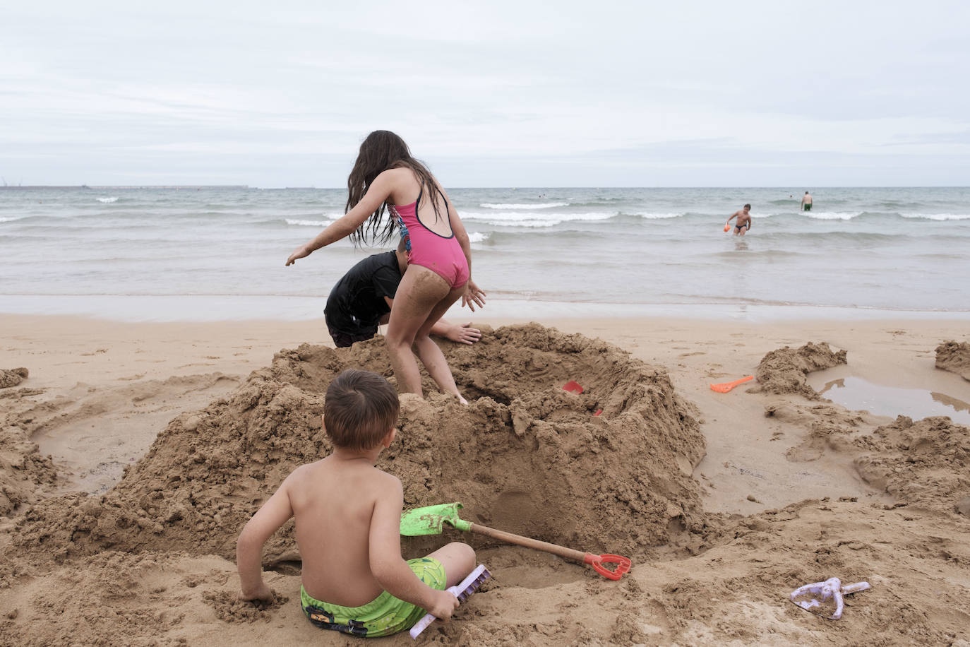 Está siendo un verano atípico en la costa asturiana, pero el mal tiempo no ha impedido que los bañistas se lancen a la playa de San Lorenzo con ganas de disfrutar del día. Algunos pasean, otros leen con la ropa puesta y los más valientes se atreven a darse un chapuzón. Cualquier plan es preferible a quedarse en casa.