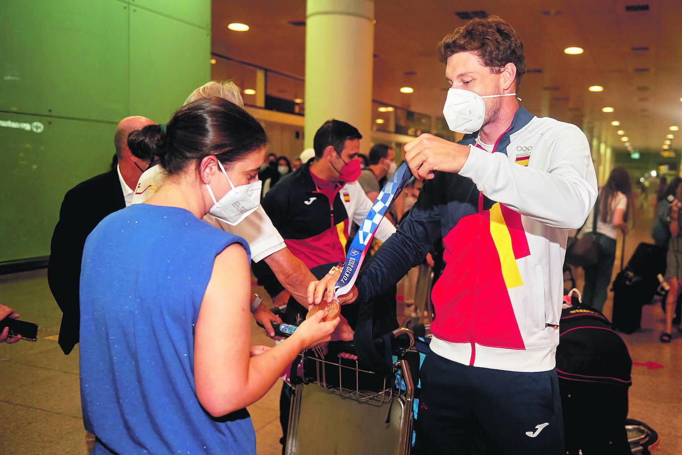 Carreño muestra la medalla a su hermana Lucía nada más aterrizar en el aeropuerto del Prat. lof