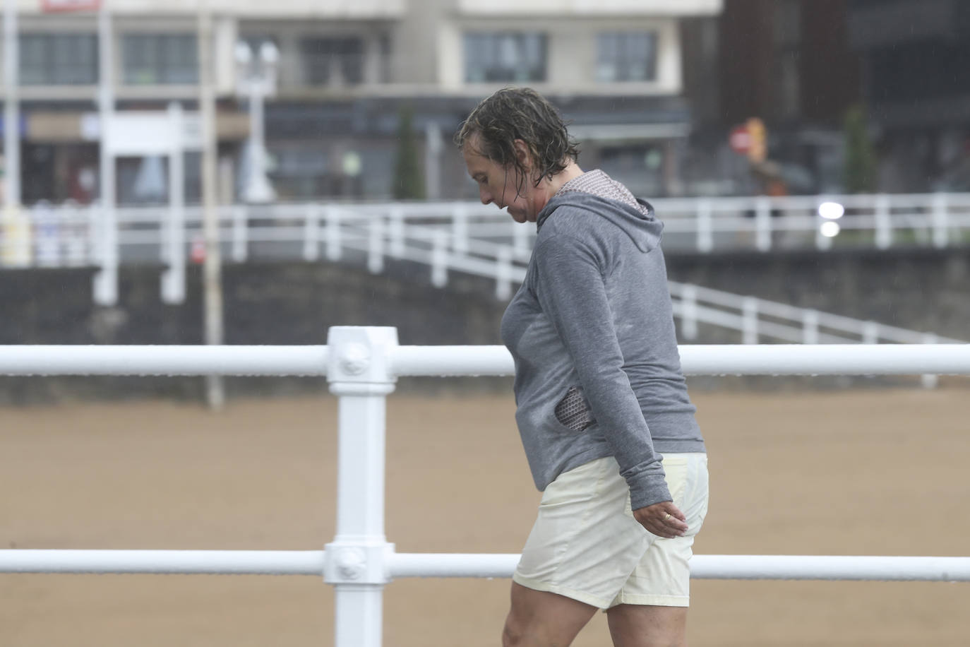 Está siendo un verano atípico en la costa asturiana, pero el mal tiempo no ha impedido que los bañistas se lancen a la playa de San Lorenzo con ganas de disfrutar del día. Algunos pasean, otros leen con la ropa puesta y los más valientes se atreven a darse un chapuzón. Cualquier plan es preferible a quedarse en casa.