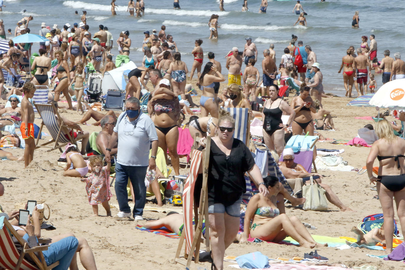 Los arenales de Gijón han estado a rebosar durante la primera parte de este soleado jueves. Sin embargo, el viento ha ido ganando protagonismo con el paso de las horas 