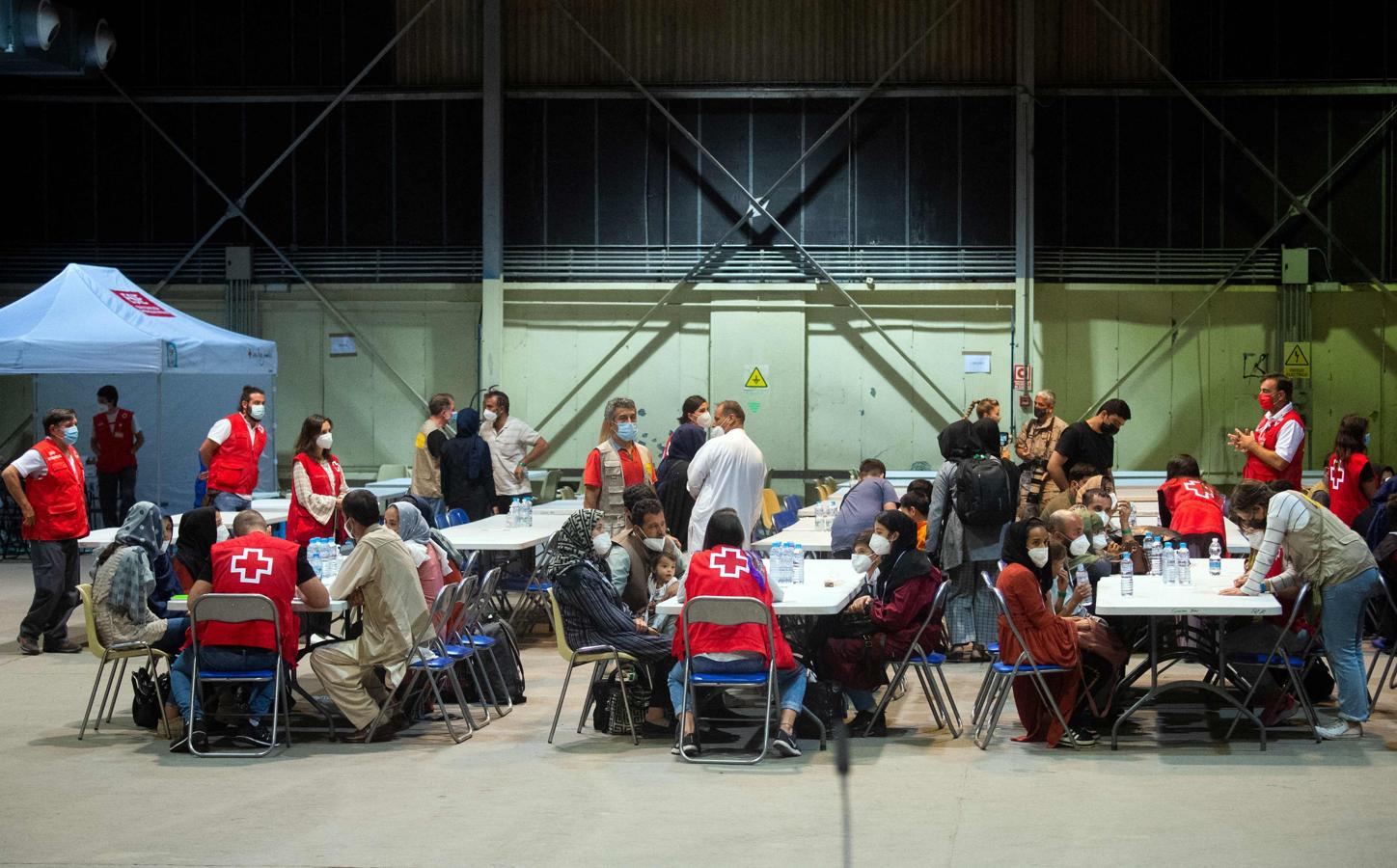 Miembros de la Cruz Roja atienden a los refugiados afganos. 