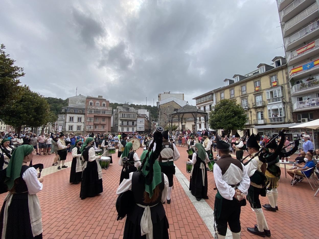 Vecinos y turistas, frente al Ayuntamiento, durante la actuación de la banda de gaitas La Reina del Truébano. 