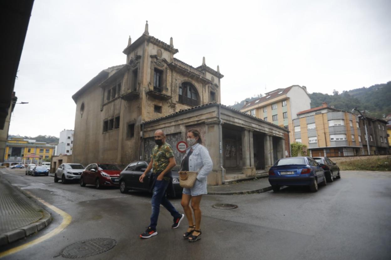 Un hombre y una mujer caminan delante del teatro Virginia, sede del futuro centro de salud. 
