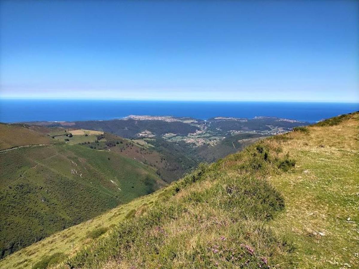 Vista a la costa asturiana desde uno de los tramos de la Ruta a las  Brañas Vaqueiras de Cudillero  en el Parque Eólico Pumar.