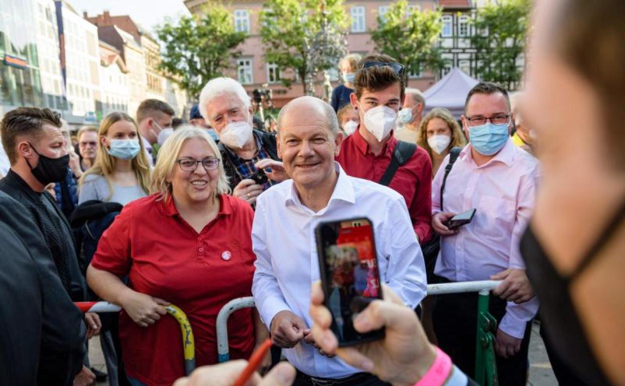 Olaf Scholz se fotografía con una simpatizante en un mitin. 