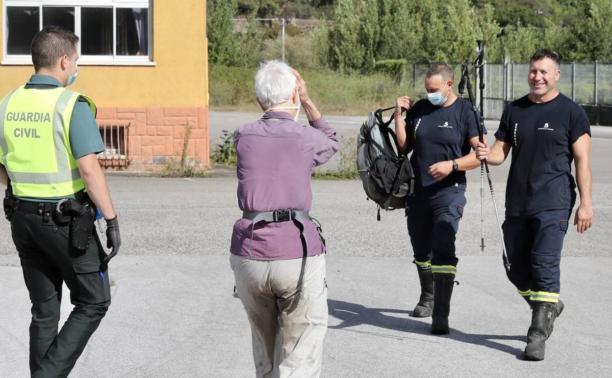 Los bomberos entregan a la mujer sus pertenencias, que transportaron en el helicóptero 