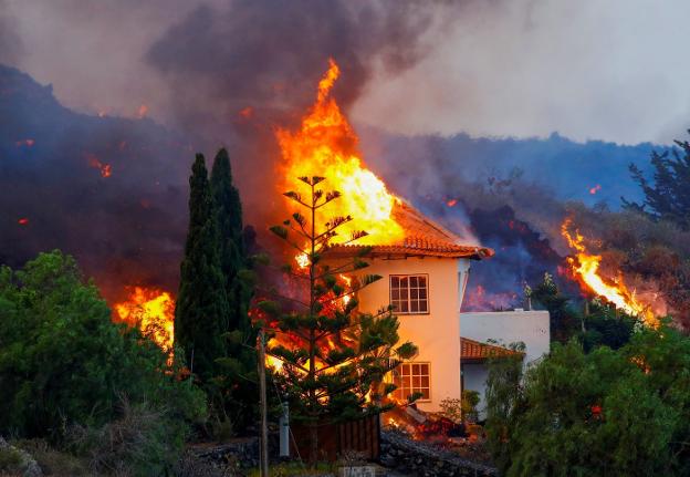 Bajo el fuego. Una casa situada en el término de Los Llanos de Aridane arde en llamas tras ser alcanzada por la lava incandescente. En algunas viviendas se escuchaban detonaciones al contactar las brasas con algún inflamable. 