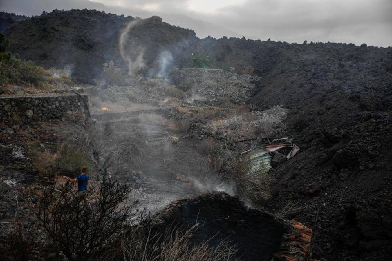 La colada de lava provocada por la erupción del volcán de Cumbre Vieja avanza arranso casas y cultivos.