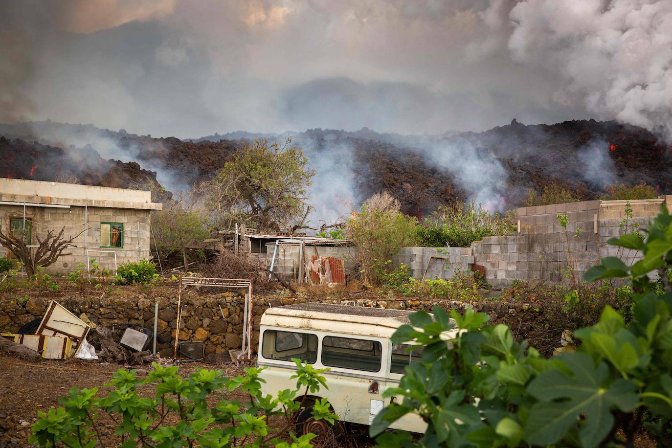 La colada de lava provocada por la erupción del volcán de Cumbre Vieja avanza arranso casas y cultivos.