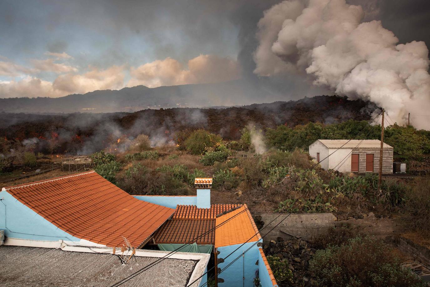 La colada de lava provocada por la erupción del volcán de Cumbre Vieja avanza arranso casas y cultivos.