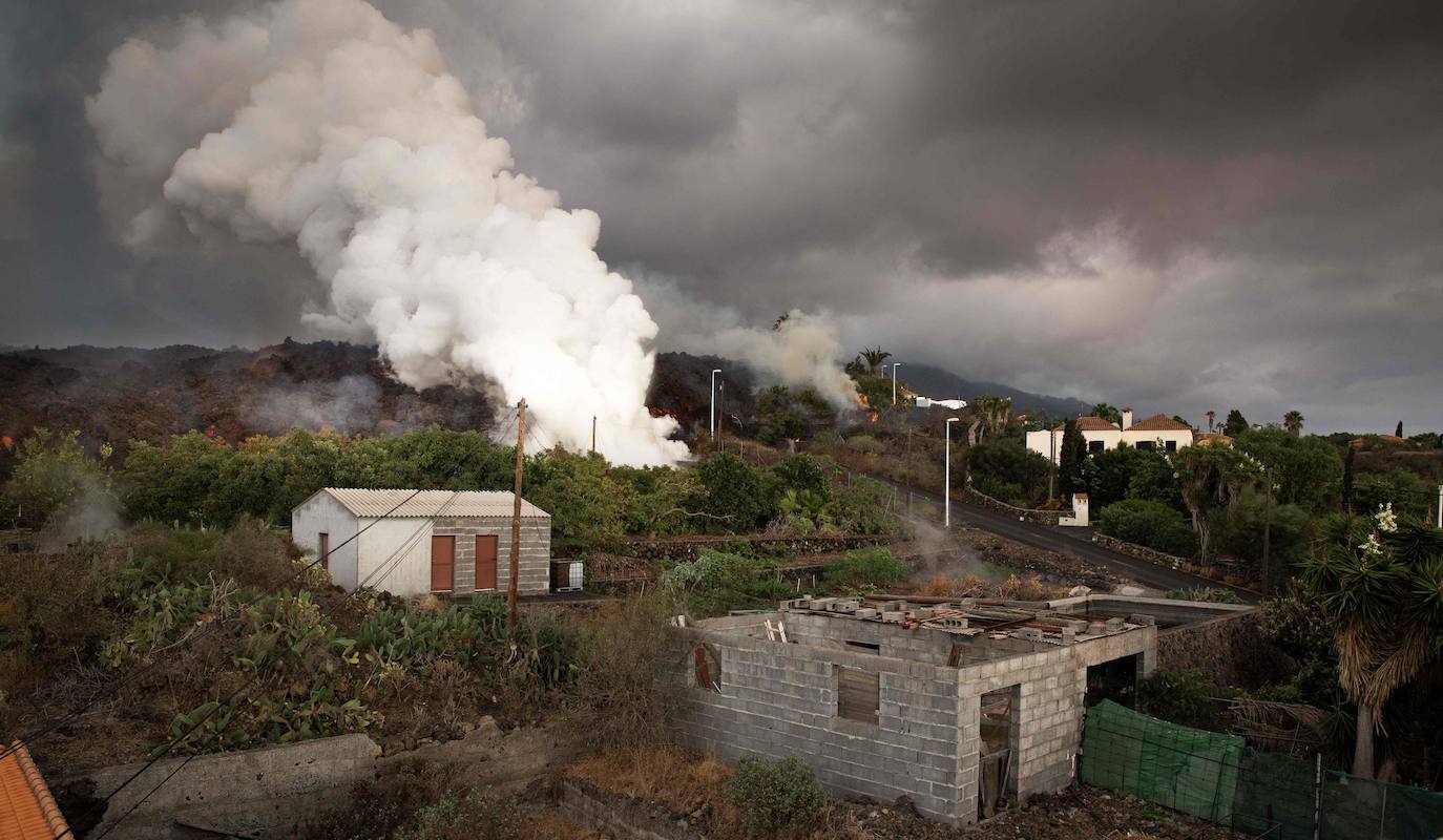 La colada de lava provocada por la erupción del volcán de Cumbre Vieja avanza arranso casas y cultivos.